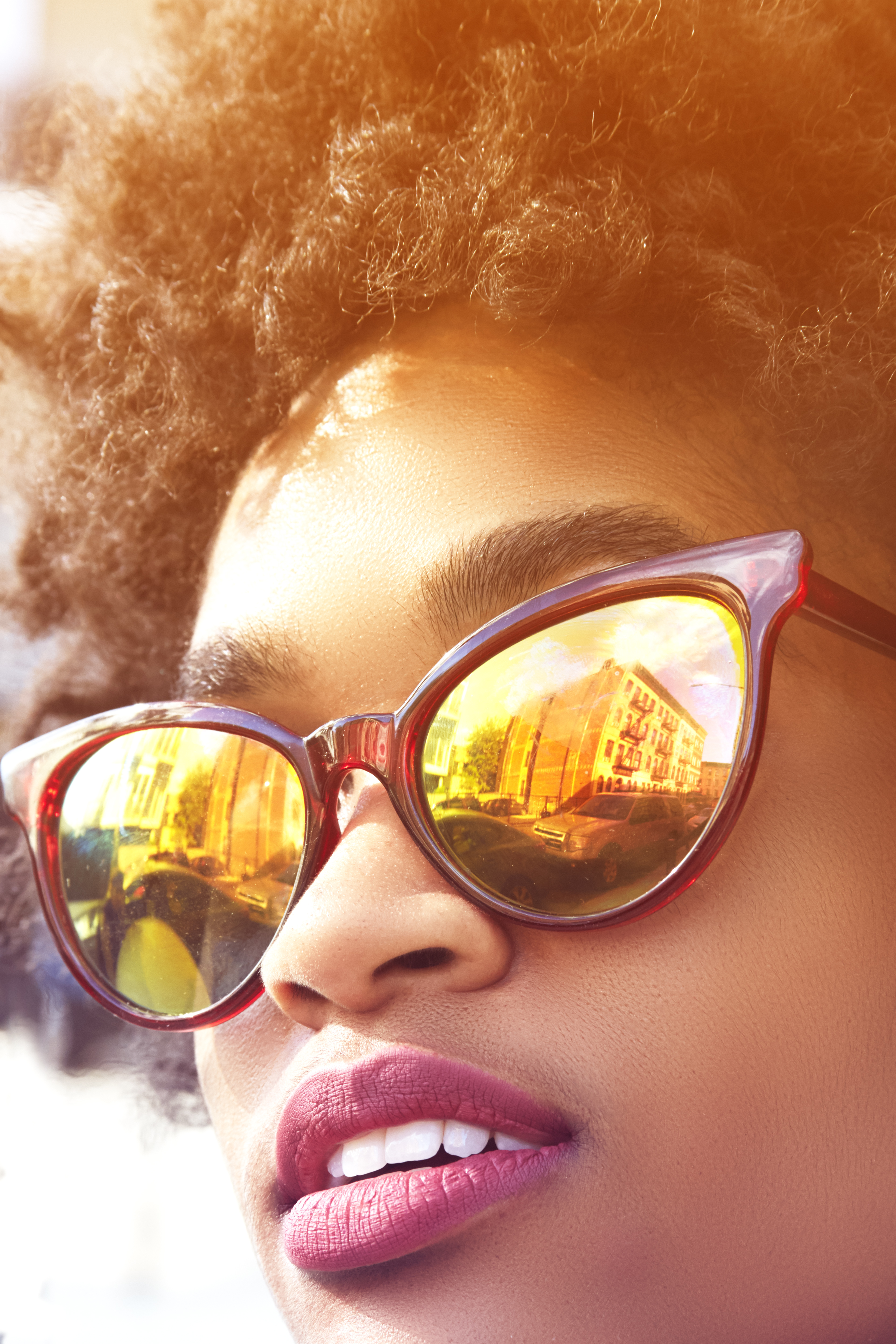 Close up portrait of young female fashion blogger with afro hair and mirrored sunglasses, New York, USA