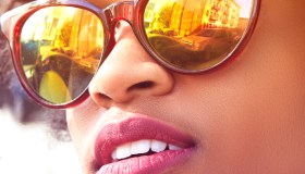 Close up portrait of young female fashion blogger with afro hair and mirrored sunglasses, New York, USA