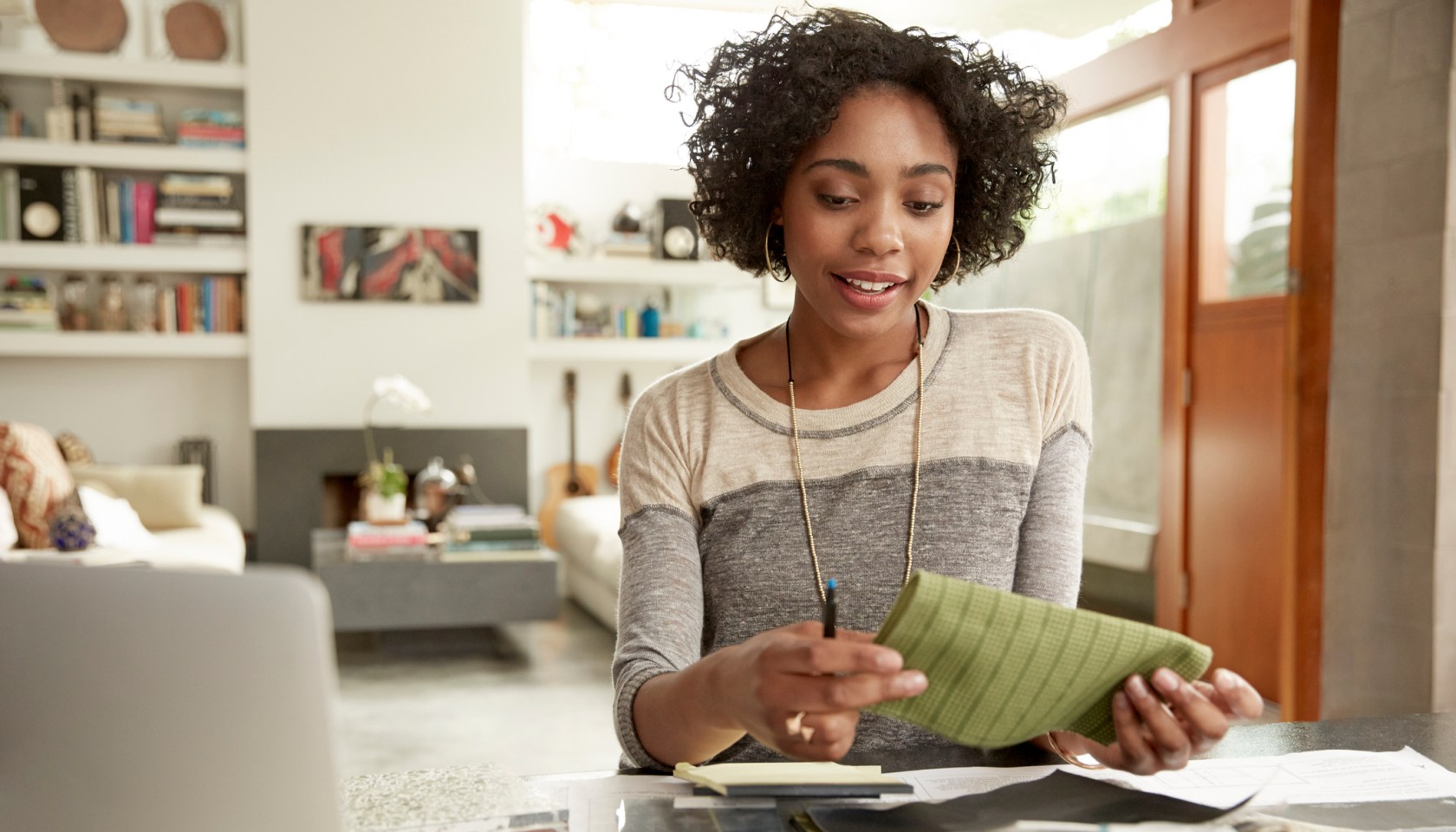Female interior designer browsing fabric swatches at home office desk