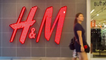 A woman seen walking in front of the H&M shop. Malaysia...