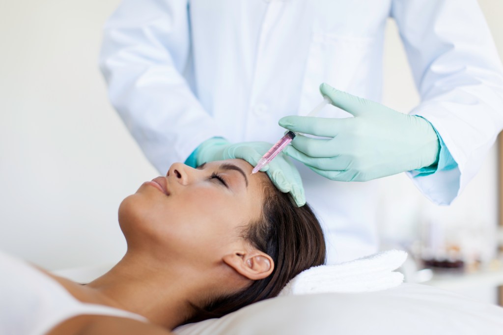 African patient getting mesotherapy done to her face.