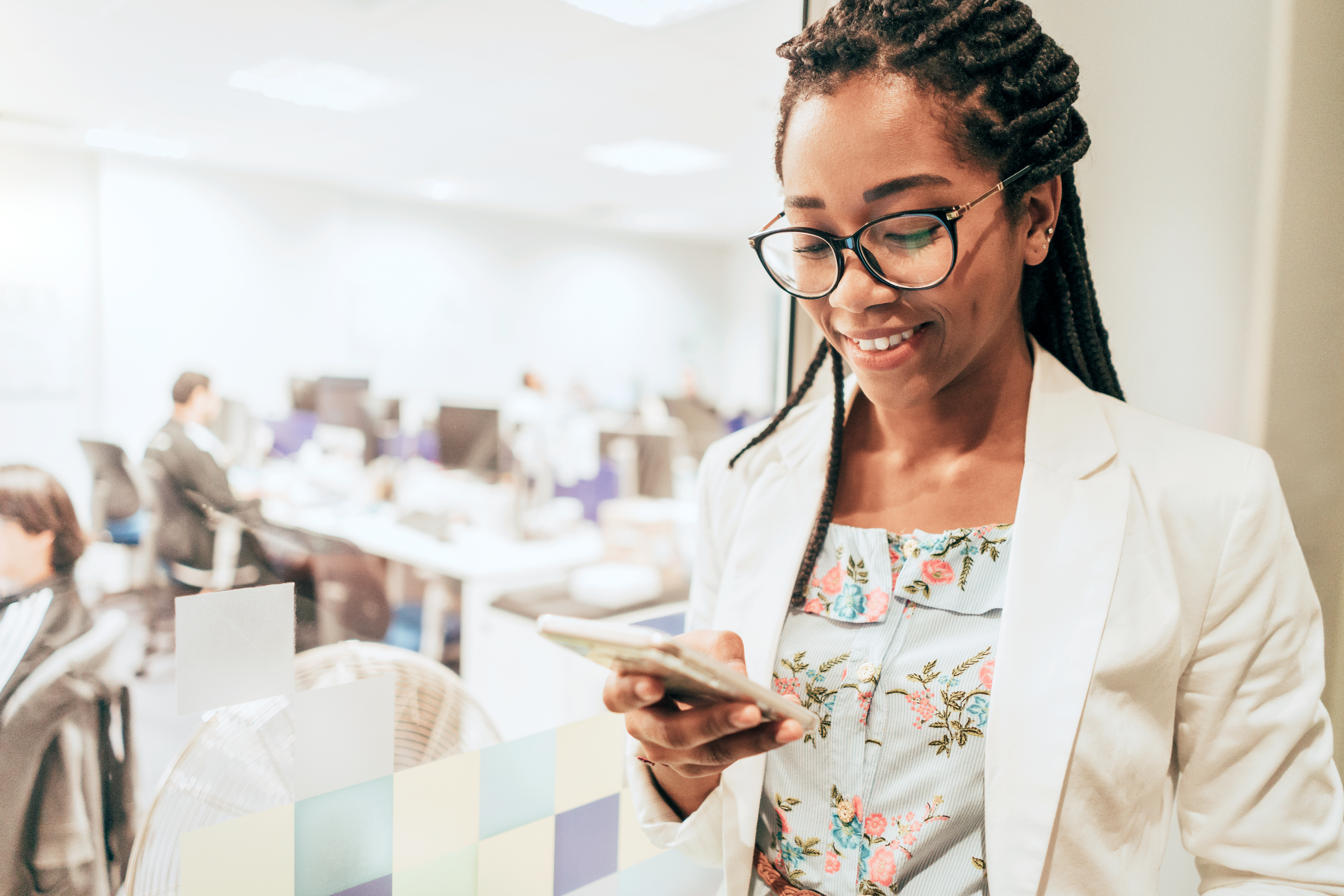 Portrait of young businesswoman holding mobile phone in creative office
