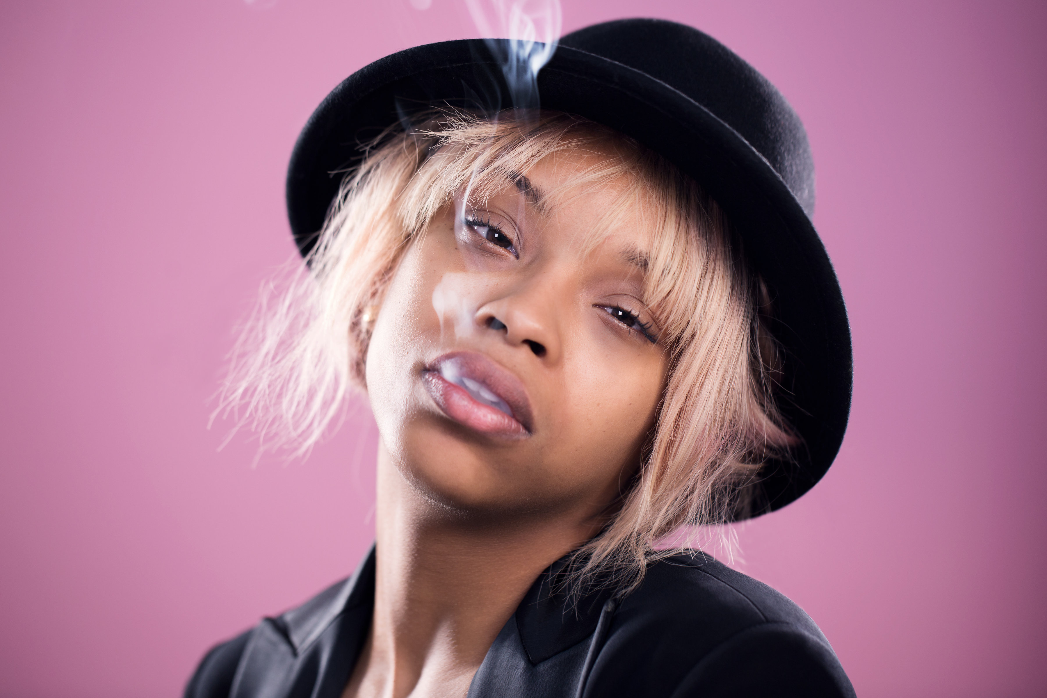 Young Ethnic Woman With Smokes Coming Out Of Her Mouth