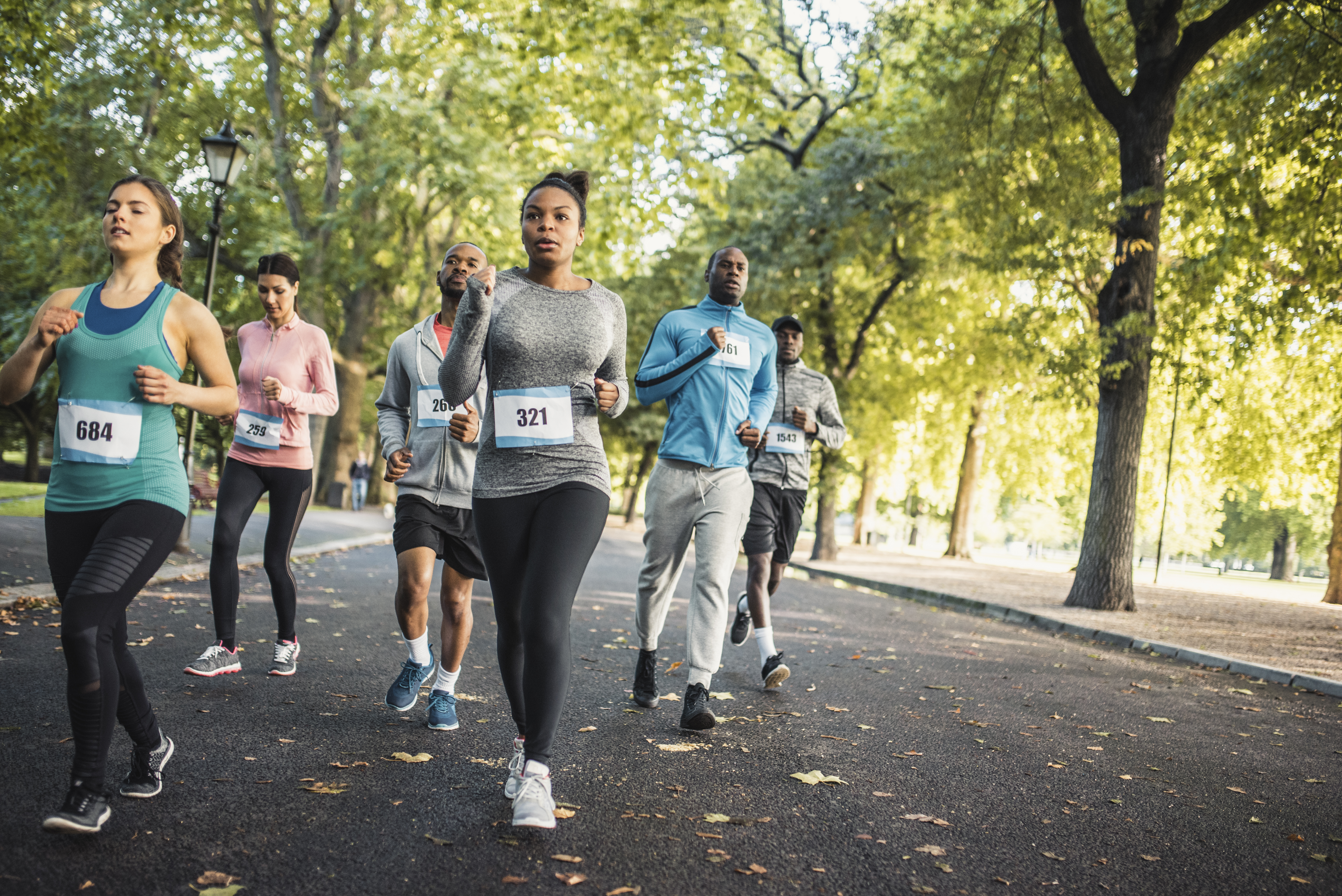 Group of people running track together in a park