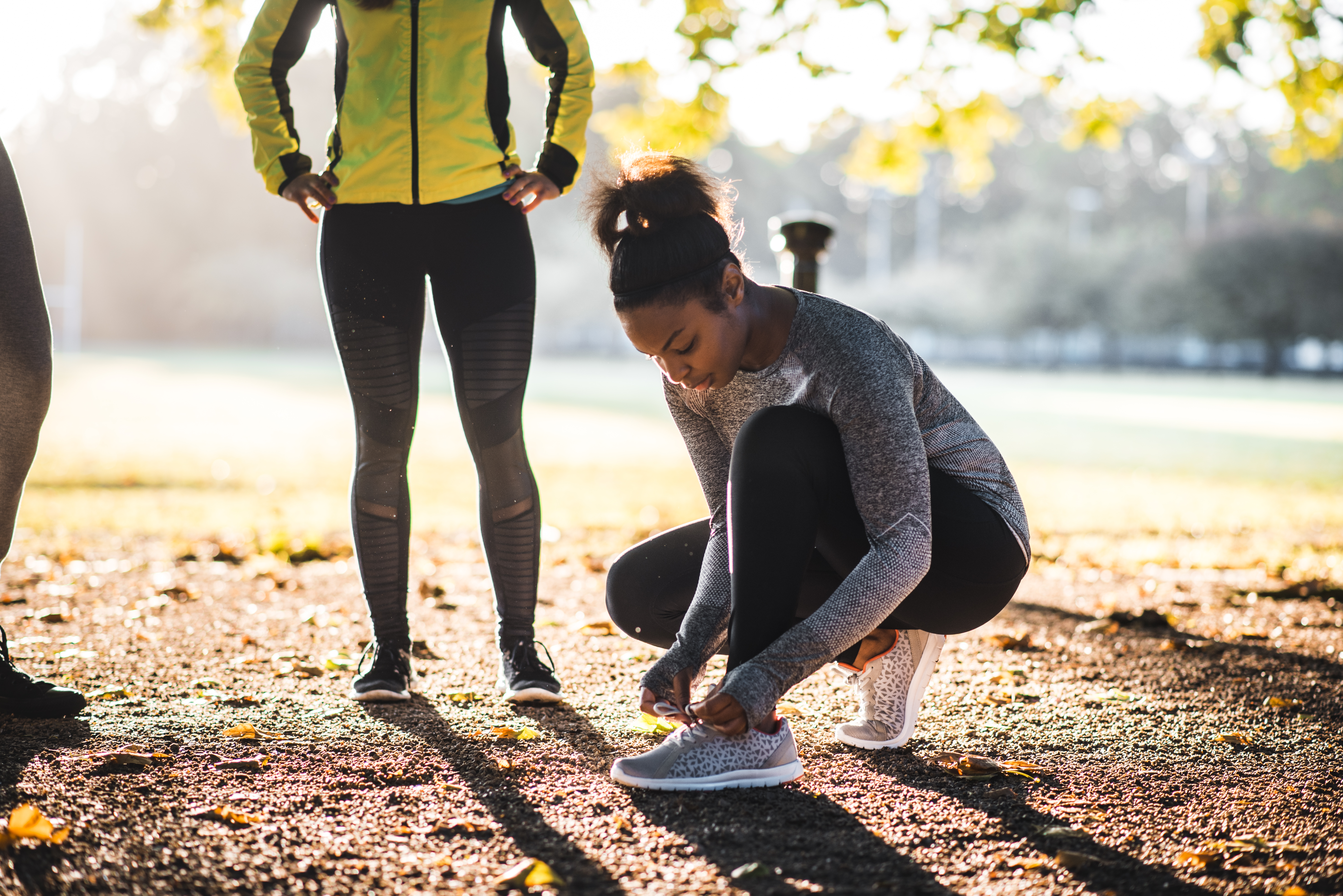 African American woman tying her shoelaces before running