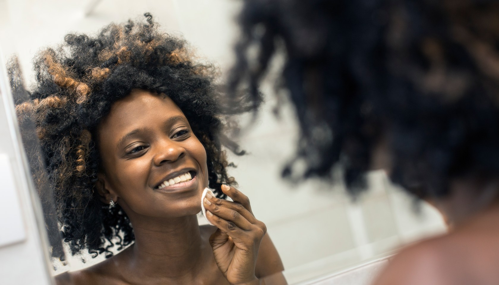 Young woman cleaning her skin