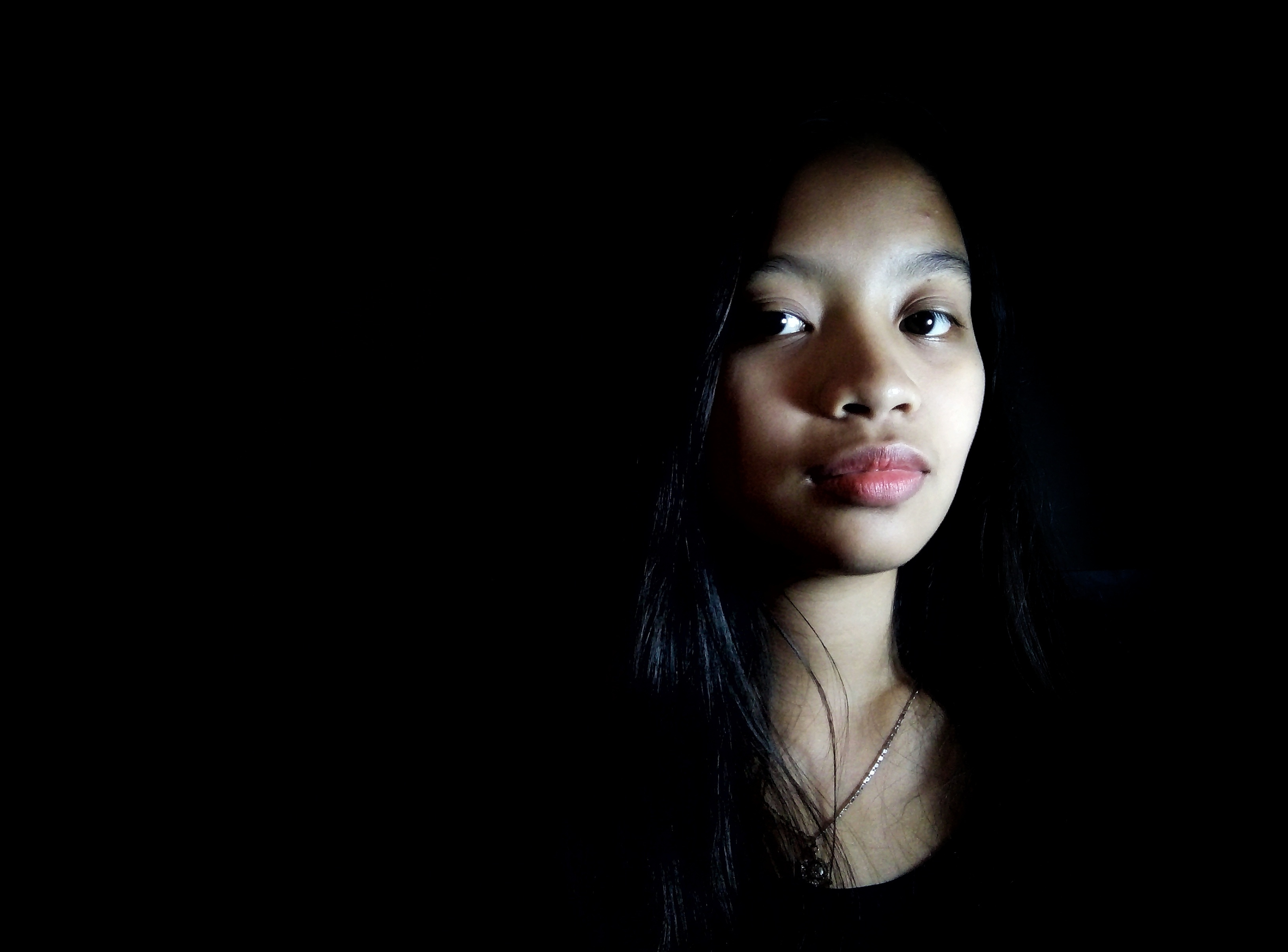 Close-Up Portrait Of Teenage Girl Against Black Background