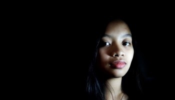 Close-Up Portrait Of Teenage Girl Against Black Background