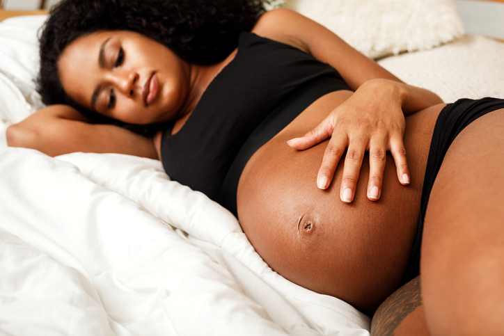 Pregnant Woman Lying On Bed At Home