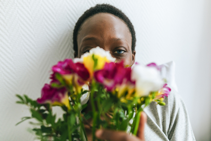 Portrait of woman behind flowers