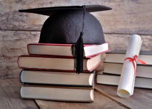 Close-Up Of Books And Mortarboard With Certificate On Table