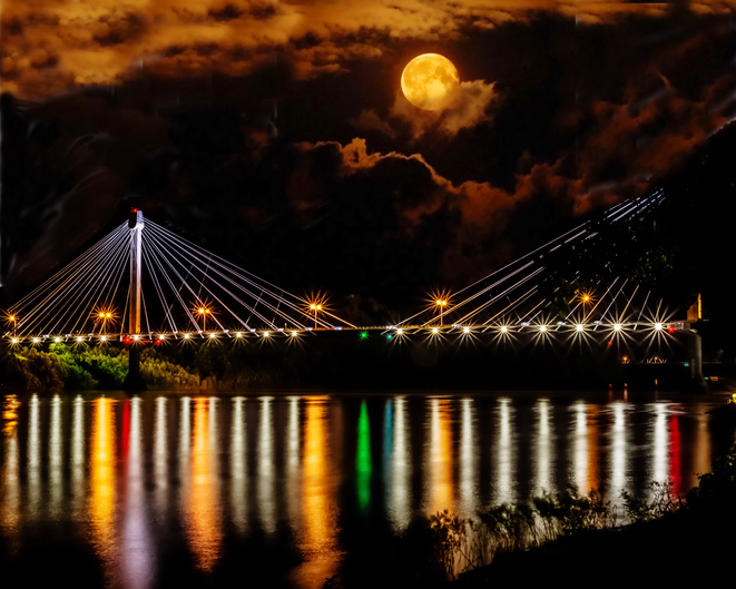 Illuminated Bridge Over River Against Sky At Night