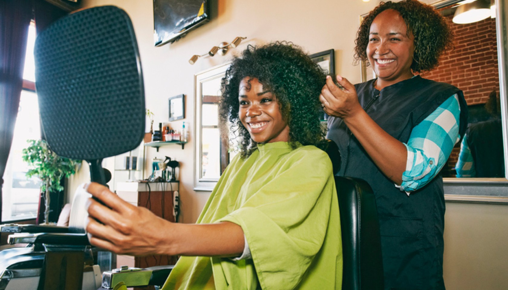 Smiling hairdresser and customer in hair salon