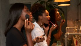 Three friends applying makeup at ladies' room