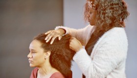 A woman having her natural afro hair groomed