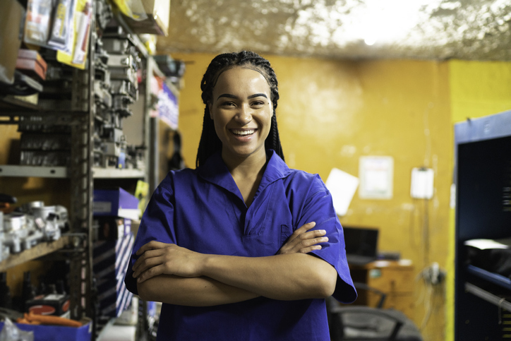 Portrait of a female mechanic with arms crossed in a auto repair shop