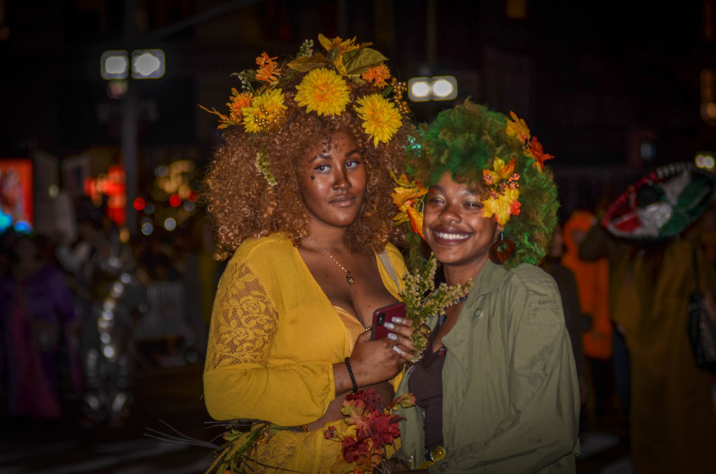 Women seen dressed in Halloween costume during the parade.