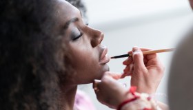 Makeup artist applies lipstick