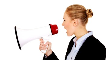 Side View Of Businesswoman Shouting On Megaphone Against White Background