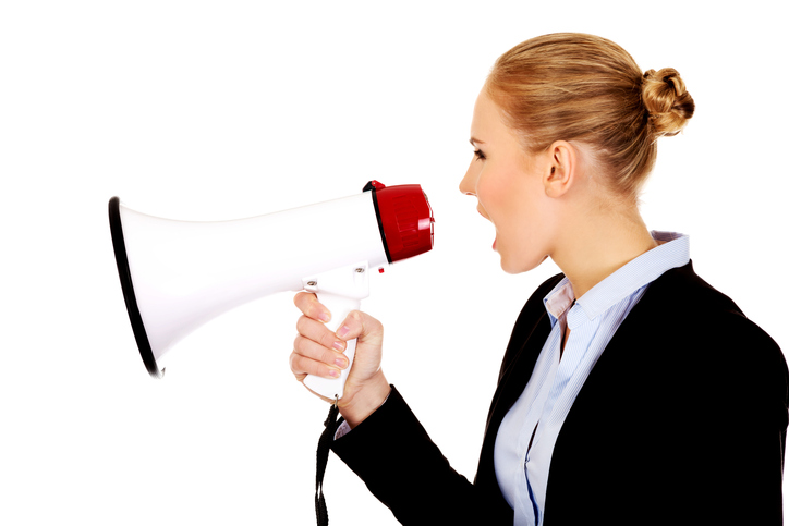 Side View Of Businesswoman Shouting On Megaphone Against White Background