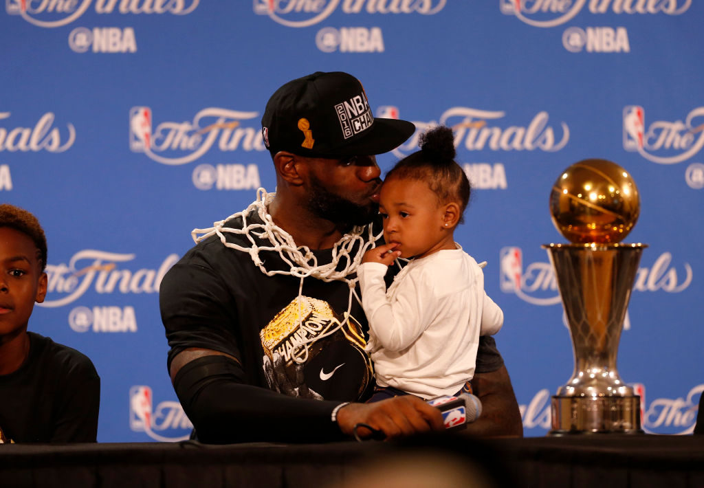 Cleveland Cavaliers' LeBron James (23) gives his daughter Zhuri Nova James a kiss during a press conference after the Cavaliers beat the Golden State Warriors in Game 7 93-89 for the NBA Finals at Oracle Arena in Oakland, Calif., on Sunday, June 19, 2016.