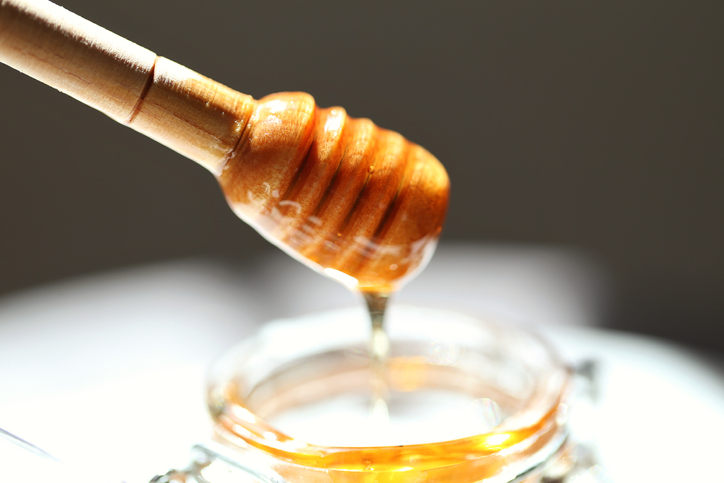 Close-Up Of Honey Dipper On Table