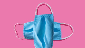 Blue medical face mask to avoid contagious diseases pattern on pink background