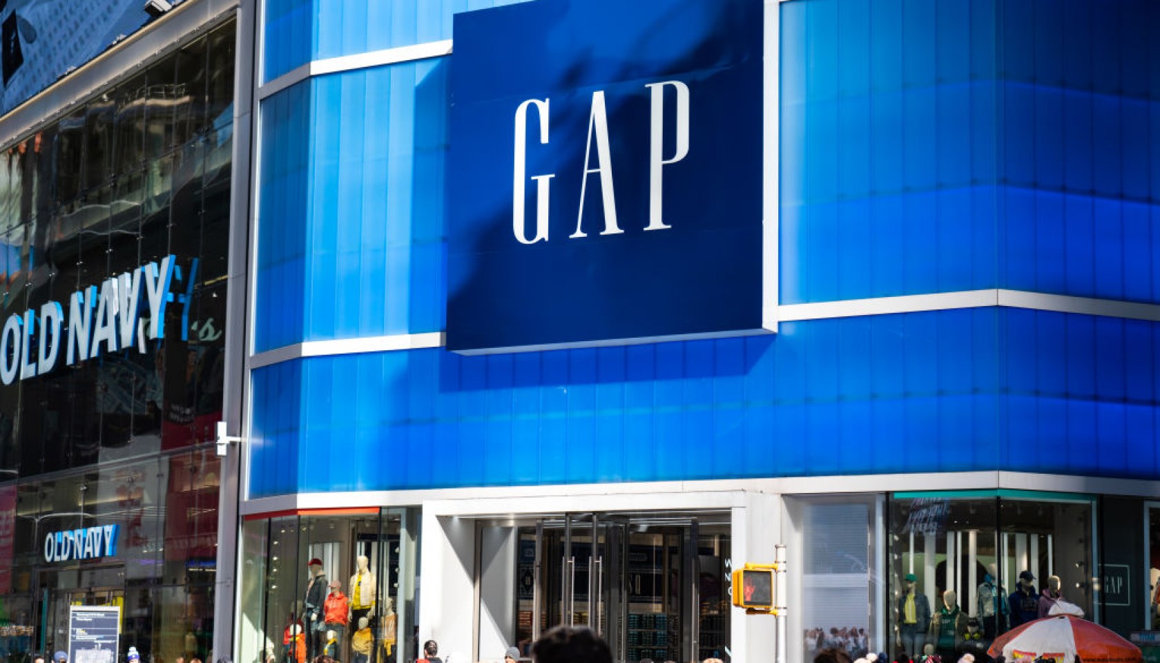 Pedestrians walk past an American worldwide clothing and...