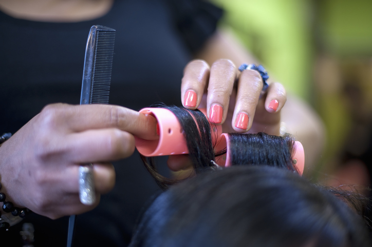 Hair Stylist Putting Rollers in Woman's Hair
