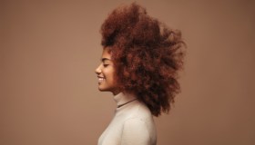 Photo of cheerful curly girl with positive emotions