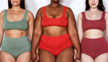 Plus size women in lingerie standing together holding hands