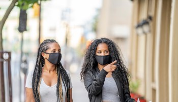 African American sisters shopping downtown wearing masks