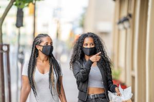 African American sisters shopping downtown wearing masks
