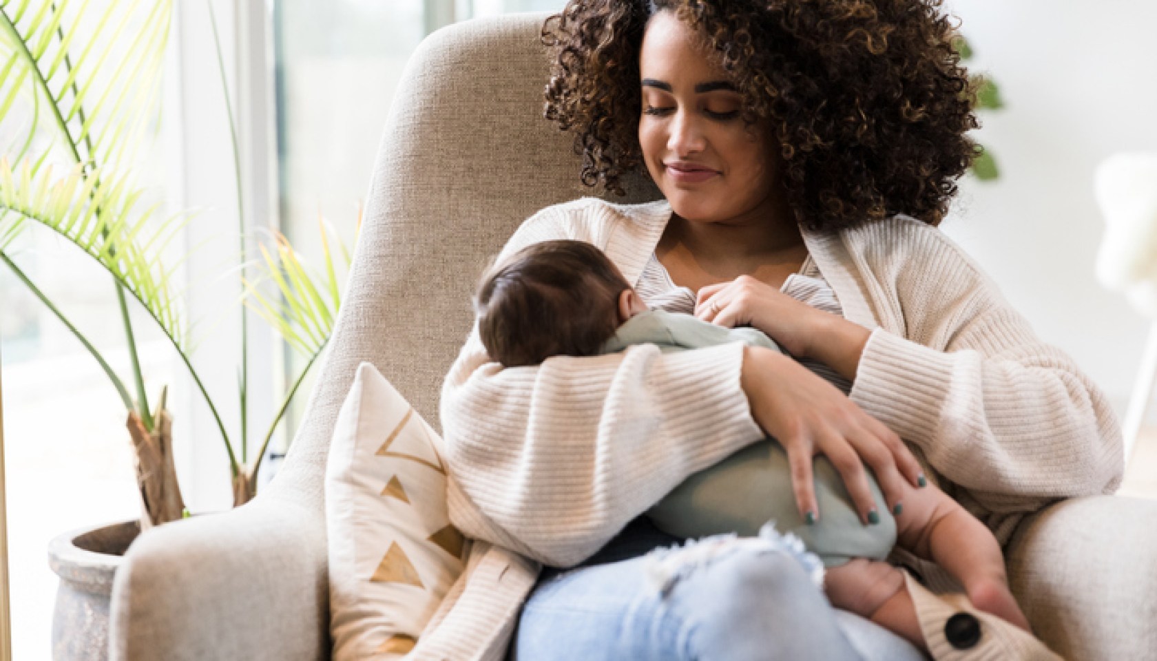 Happy mom breastfeeds her infant son