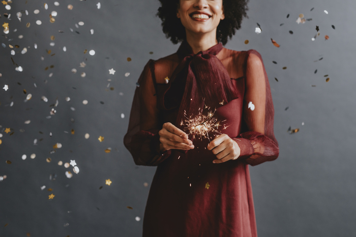 Portrait of an Anonymous Smiling Woman in a Festive Red Dress Holding Sparklers, Celebration Concept