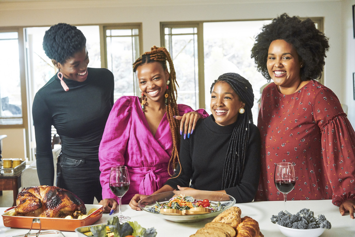 Happy friends having fun at dining table in party