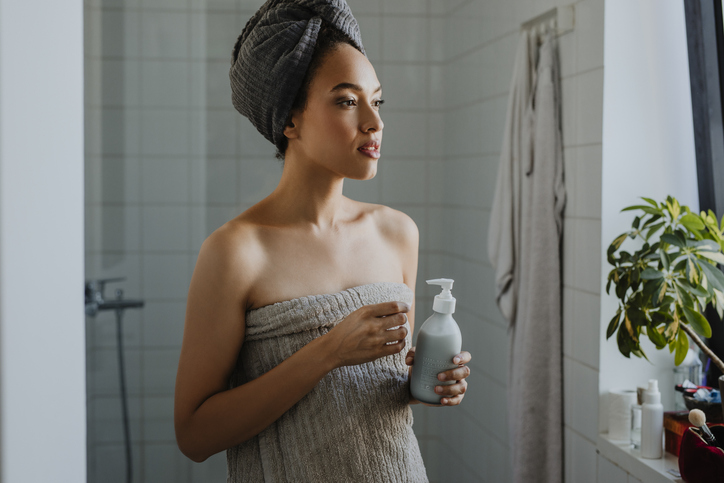Beautiful Afro Woman Standing in the Bathroom Holding Liquid Soap