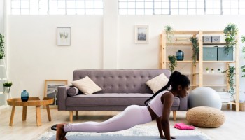Young woman doing yoga in living room at home