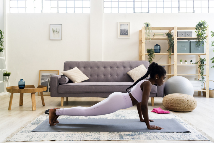 Young woman doing yoga in living room at home