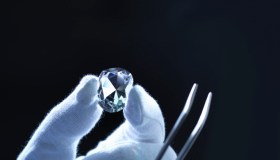 Jeweller inspecting replica diamonds with gloved hand