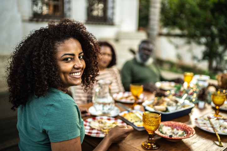Portrait of a mid adult woman eating with family on Christmas at home