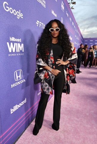 Singer H.E.R. poses on the red carpet at the Billboard Women in Music 2022 - Red Carpet