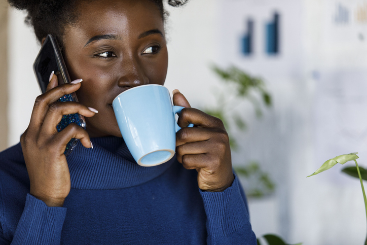 Businesswoman sipping coffee and talking on the phone