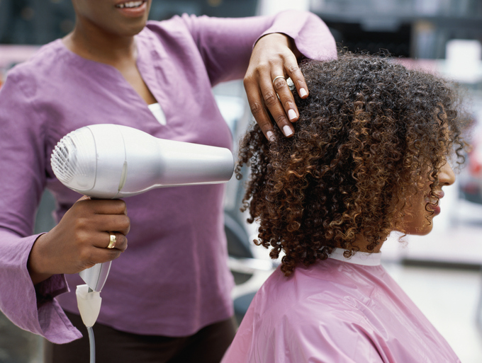 Side profile of a woman having her hair dried with a hair dryer