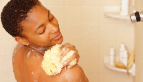 Woman washing using sponge in shower
