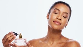 Fragrance, spray and bottle with black woman in studio for beauty, skincare and cosmetics. Perfume, face and model spraying body product, parfume and makeup for smell, essence and aesthetic mockup