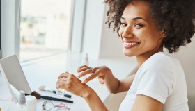 Woman applying a cosmetic product from a transparent plastic bottle