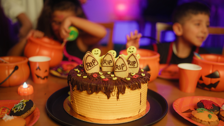 Halloween party cake and children in background