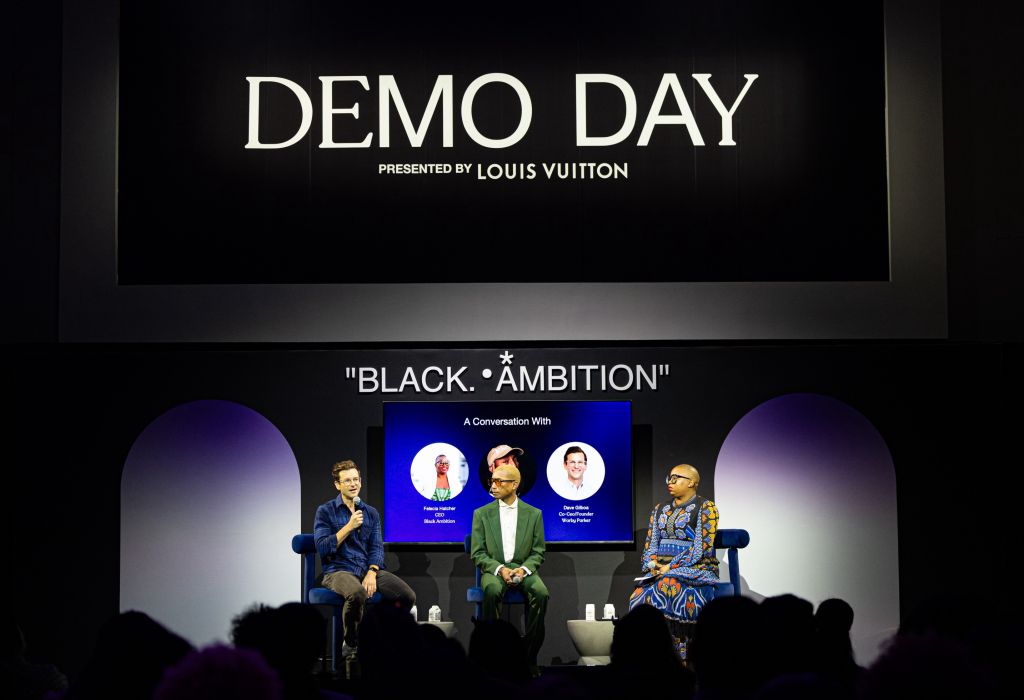 Black Ambition Demo Day 2023 stage with Warby Parker Co-CEO/Founder Dave Giboa, Black Ambition CEO Felicia Hatcher, and Black Ambition Founder Pharrell Williams