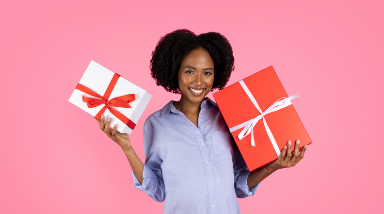 Happy millennial black lady shows boxes with presents, enjoy celebrate party of unborn child
